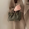 Minimalistische olivgrüne Beuteltasche mit goldenem Logo und geknoteten Griffen - Grün