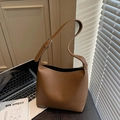 Braune Beuteltasche aus Leder mit Kieselmaserung und silberner Schnalle am Schreibtisch - Teebraun