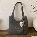 Detail of dark grey canvas tote bag with embroidered text and a cute plush dog charm - With Pendant / Dark Brown