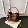 Dark brown pebble leather bucket bag with contrasting beige handle and gold twist lock - No Pendant / Brown