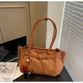 Dettaglio di borsa tote in pelle scamosciata vintage con fibbia e ciondolo pompon - Marrone con ciondolo