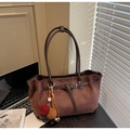 Dettaglio della borsa tote in pelle scamosciata marrone con nappa etnica colorata - Caffè con Ciondolo