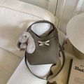 Détail du sac seau en cuir taupe avec fermoir en croix et breloque lapin en peluche - Gris Éléphant avec Pendentif