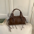 Detailed view of dark brown bowling bag with silver grommets and fringe tassels - Brown