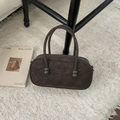 Close-up of a vintage dark brown bowling bag with unique ball-jointed handles on a cozy rug - Coffee without Pendant