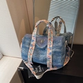 Denim blue cylindrical handbag with floral embroidery on straps and mirror reflection - Blue