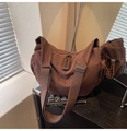 Detail view of brown pleated canvas bag with woven zippers and wide fabric strap - Coffee
