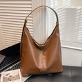 Grote bruine leren hobo tas met witte verticale stiksels en metalen logoplaat - Bruin