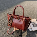 Bolso cubo vintage en cuero brillante granate con hebilla decorativa y colgante tejido - Con Colgante / Burdeos