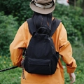 Zaino outdoor nero versatile con tasche multiple e maniglia superiore in ambiente naturale - Con Ciondolo / Nero