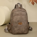Dettaglio dello zaino vintage in pelle marrone con chiusura in bronzo e tasche multiple - Marrone
