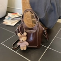Dark brown leather bucket bag with top handles, crossbody strap and cute teddy bear charm - With Charm / Brown