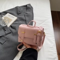 Pink minimalist square handbag with top handle and golden buckle in lifestyle setting - Pink