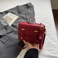 Red matte leather small square bag with decorative gold buckles and adjustable strap - Burgundy