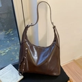 Dettaglio borsa hobo marrone scuro vintage con cerniera verticale e borchie metalliche - Marrone