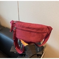 Detail of burgundy corduroy crossbody bag featuring dual zippers and woven pulls - Burgundy