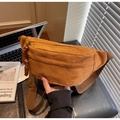 Close-up of tan corduroy crossbody bag featuring dual zippers and woven pulls - Brown