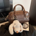 Bolso boston de cuero marrón con colgante de conejo de peluche blanco y detalles oro - Café con Colgante
