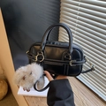 Bolso Boston negro con costuras blancas, herrajes dorados y un colgante de conejo suave - Negro con colgante
