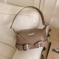 Bolso de hombro marrón moka de ecocuero con hebillas plateadas sobre sofá blanco - Arena