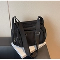 Detail of black corduroy tote bag featuring multi-zipper pockets and wide adjustable strap - Black