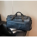 Detailed view of dark blue gym bag with waterproof nylon fabric on leather seat - Blue
