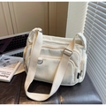 Detail view of cream corduroy tote bag with multiple zip pockets and adjustable strap - Off-white