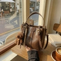 Brown vintage style bucket bag with teddy bear charm on wooden cafe table - Brown (With Pendant)