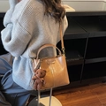 Brown vintage bucket bag with detachable strap and cute teddy bear charm on model - Khaki (With Charm)