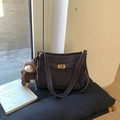 Close-up of retro bucket bag with gold metal buckle and cute teddy bear pendant - With Charm / Brown