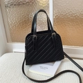 Bolso de mano negro con textura trenzada, hebillas plateadas y correa bandolera fina - Negro