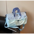 Close-up of lightweight travel bag with thick quilted handles and mesh front pocket - Blue