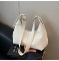 Detail of white lychee-pattern leather underarm bag with silver buckle and semi-moon shape - White