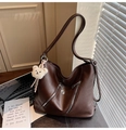 Detail of dark brown tote bag featuring dual metal zippers and cute teddy bear charm - Brown