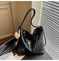 Close-up of black PU leather hobo bag featuring parallel silver zippers and a cute bear charm - Black