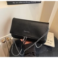 Detail of black lychee grain leather crossbody bag with silver chain and white logo - Black