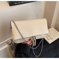 Close-up of beige pebble leather handbag featuring silver chain strap and dual zippers - Off White