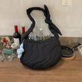 Black quilted crescent shoulder bag with wavy stitching and blue puffy knot charm - Black