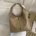 Minimalist brown leather tote bag with silver rings on a neutral textured sofa - Khaki