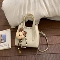 Détail du sac seau en cuir blanc crème avec breloque ours et bandoulière amovible - Avec Pendentif / Blanc