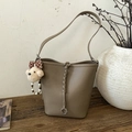 Detail showing pebbled clay brown leather texture and woven strap with bear charm - With Charm / Elephant Gray