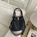 Detail of black pebbled leather bucket bag with gold hardware and geometric strap - Black