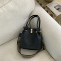 Detail der schwarzen Beuteltasche mit gewebtem Riemen im Ethno-Stil und goldenem Drehverschluss - Schwarz