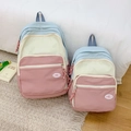 Dettaglio del set di zaini patchwork macaron con colori pastello e logo del marchio - Grande / Rosa scuro