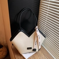 Close-up van geweven beige shopper met zwarte bies en een elegante decoratieve zijden sjaal - Beige en zwart