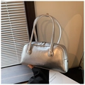 Détail du sac argenté avec texture métallisée froissée et logo de marque embossé - Argenté