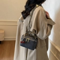 Grey woven box handbag with gold handle and cherry charm shown on model in beige coat - Gray With Pendant