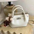 Off-white bucket bag in lychee texture with metal clasp and plush monkey pendant - Beige With Charm