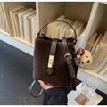 Détail du sac seau en daim marron avec fermoir doré et breloque ours en peluche - Café avec Pendentif