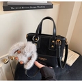 Dettaglio di una borsa a secchiello nera con logo dorato e ciondolo a coniglietto grigio - Con Ciondolo in Peluche / Nero